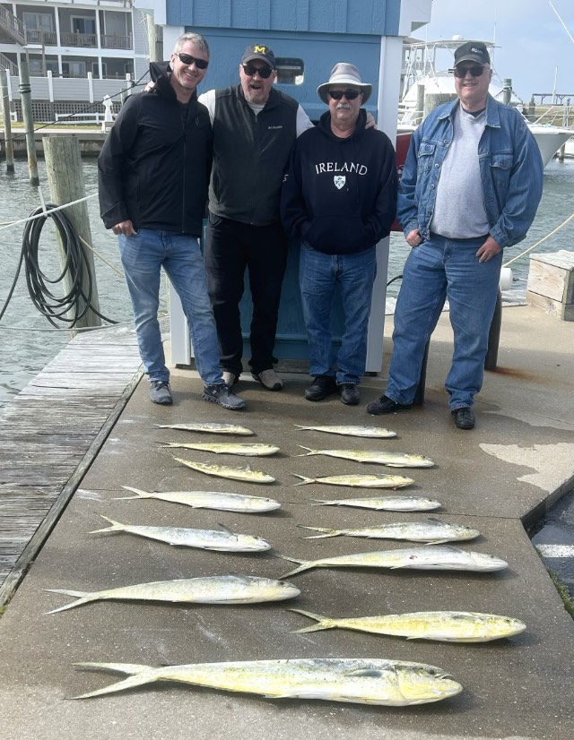 Fishing party at the dock with their catch of mahi.