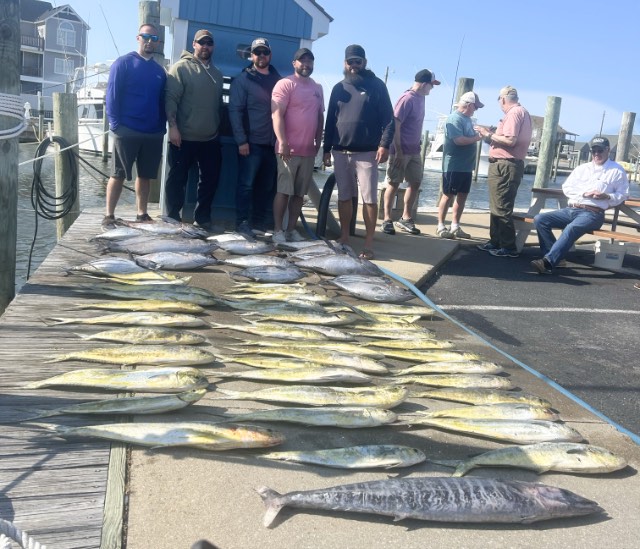 Fishing party at the dock with their catch of mahi, wahoo, and tuna.